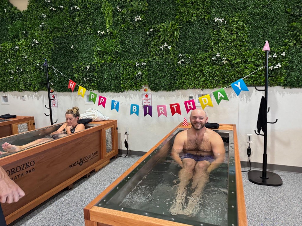 Couple celebrating a birthday in cold plunge tubs at Yoga Cold Bath