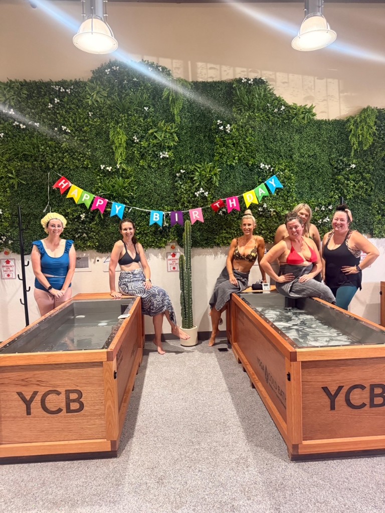 Group celebrating a birthday with cold plunge tubs at Yoga Cold Bath